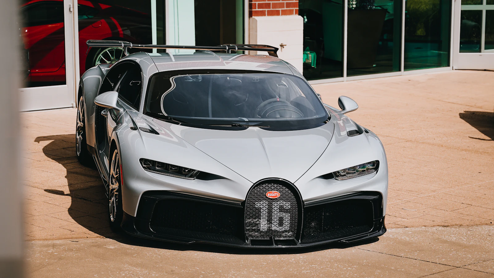 A silver Bugatti Chiron Pur Sport parked in front of a building